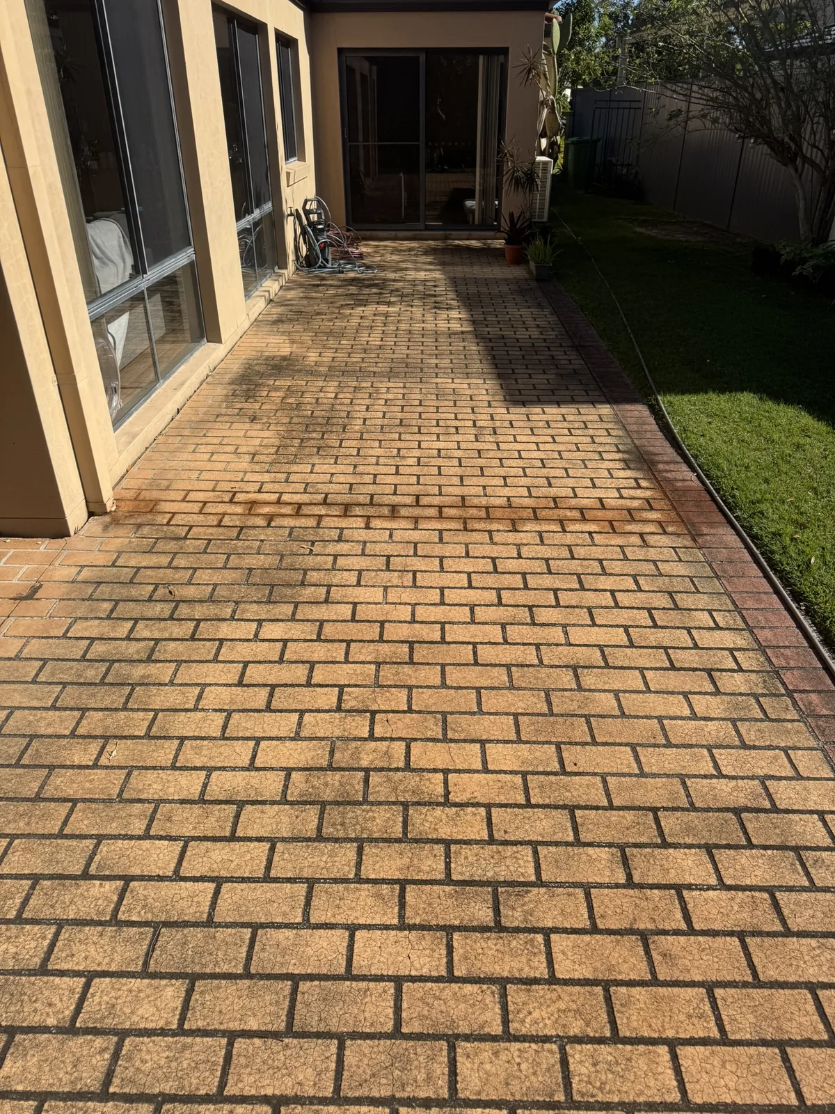 Outdoor pavers covered in dirt and black stains — before